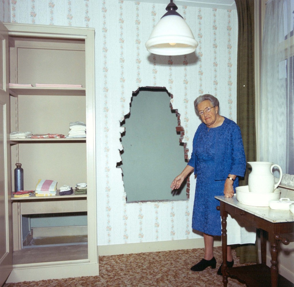 Corrie Ten Boom stands in front of hiding place where her family concealed Jews from the Nazis.